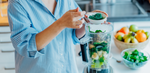 Woman making a smoothie with Greens Powder