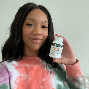 A customer showcasing a bottle of Pattern Wellness Turmeric Curcumin.