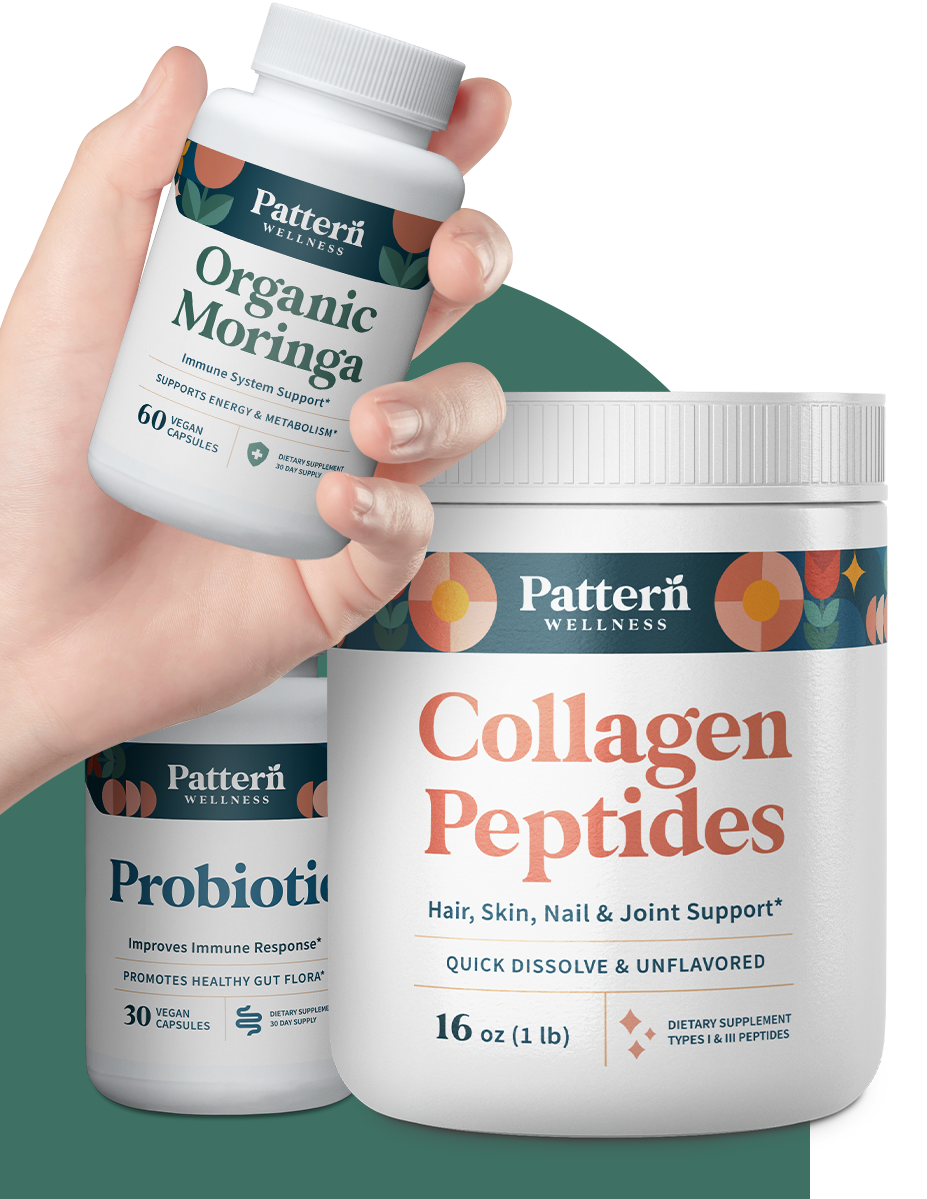 The Beauty Bundle. A hand is holding the Organic Moringa bottle.