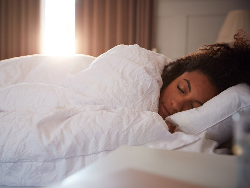 A woman peacefully sleeping in bed.