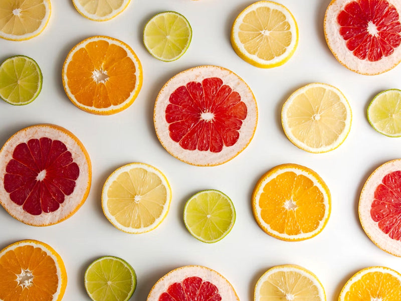 A colorful display of citrus fruits, including whole oranges and lemons.