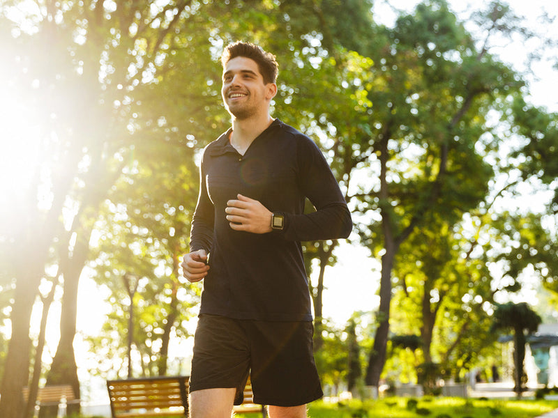 A man running energetically in a park.