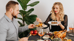 Couple enjoying a holiday meal with shared dishes at a festive dinner table