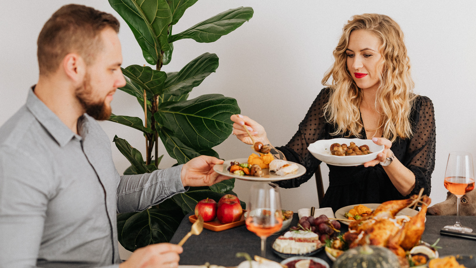 Couple enjoying a holiday meal with shared dishes at a festive dinner table