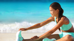 woman in gym clothes stretching for a run on the beach