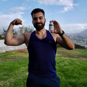 A male customer with a cheerful expression, showcasing a bottle of Pattern Wellness Berberine.