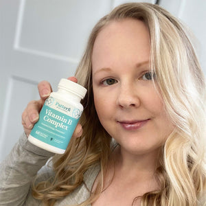 A female customer smiling while holding a bottle of Pattern Wellness Vitamin B Complex.