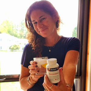 A satisfied female customer proudly displays a bottle of Pattern Wellness Resveratrol.