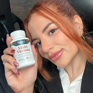 A satisfied female customer proudly displays a bottle of Pattern Wellness Multivitamin.