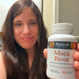 A satisfied female customer proudly displays a bottle of Pattern Wellness Maca Root.