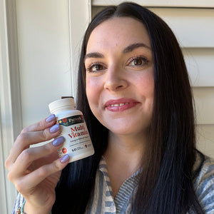 A female customer smiling while holding a bottle of Pattern Wellness Multivitamin.