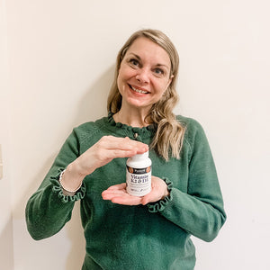 A customer is proudly flexing a bottle of Pattern Wellness Vitamin K2 & D3.