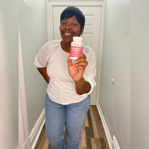 A female customer with a bright smile holding a bottle of Pattern Wellness Menopause Complex.