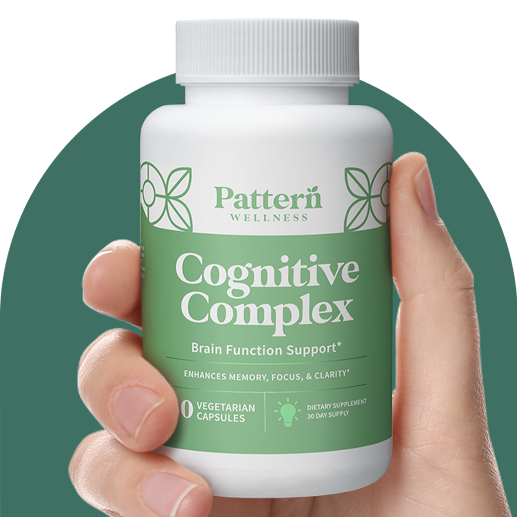 A hand holding a bottle of Pattern Wellness Cognitive Complex.