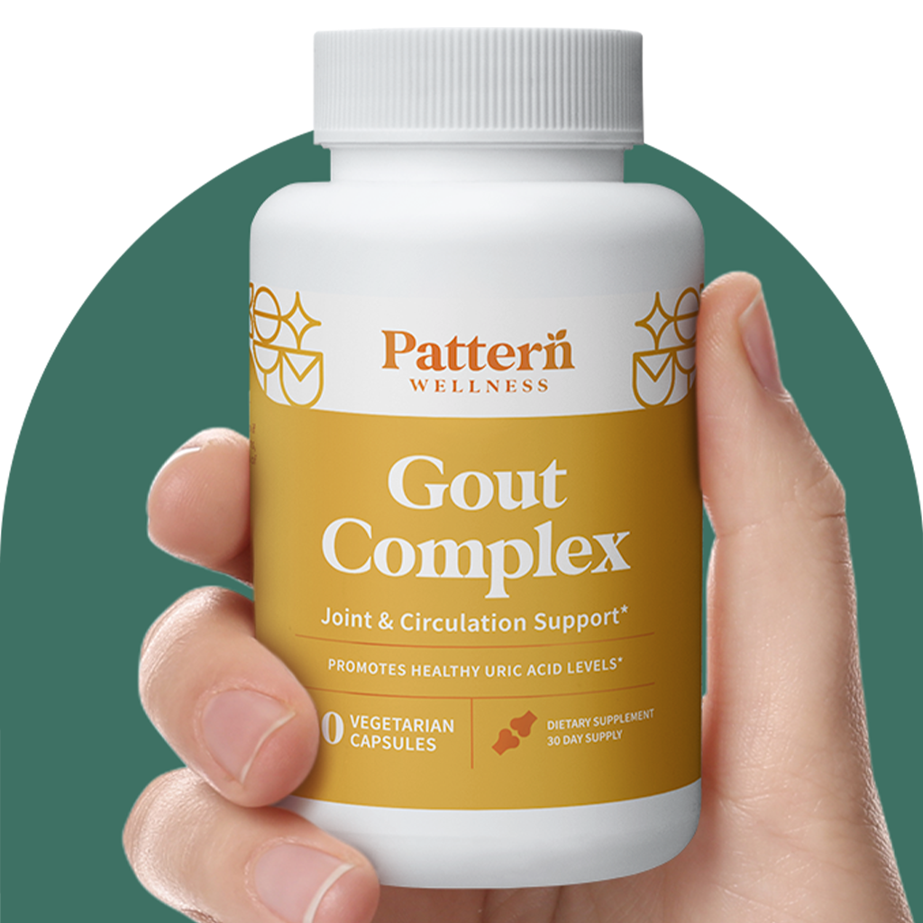 A hand holding a bottle of Pattern Wellness Gout Complex.