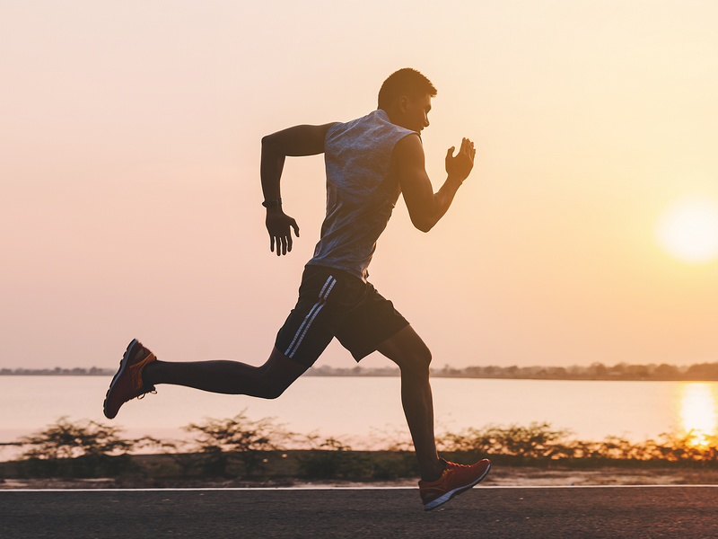 A young man is jogging along the road.