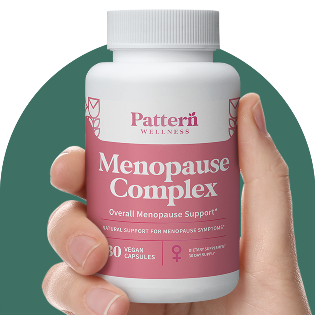 A hand holding a bottle of Pattern Wellness Menopause Complex.