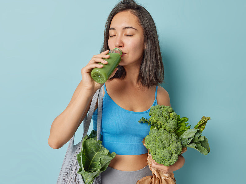 A woman enjoying a refreshing green smoothie.