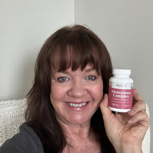 A cheerful customer showcasing a bottle of Pattern Wellness Menopause Complex.