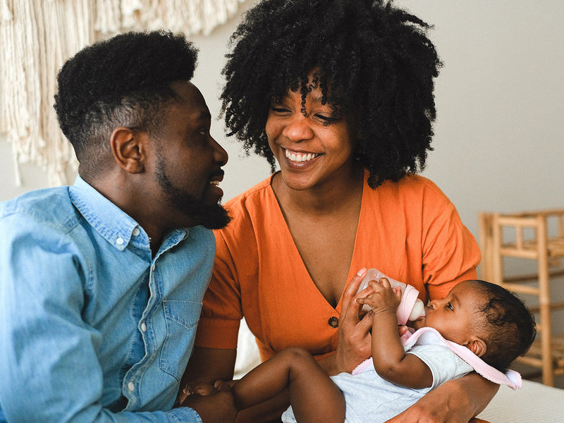 A loving couple joyfully holds their baby.